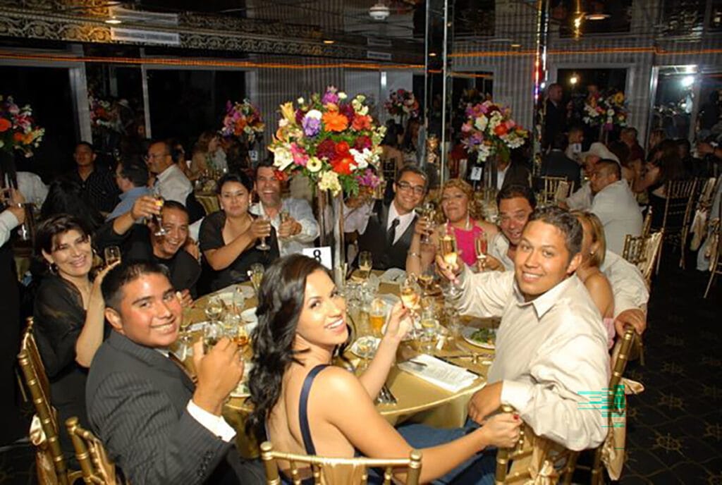 FSY – Corporate Events 2024 – FantaSea One (46)- Resized Guests raising champagne glasses at round tables with tall floral centerpieces in a mirrored banquet room